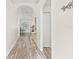 Hallway with wood floors, white walls, decorative accents, and arched doorways leading to other rooms at 2641 Big Pine Dr, Holiday, FL 34691