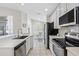 Well-lit kitchen showcasing stainless steel appliances and white cabinetry against tiled floors at 2641 Big Pine Dr, Holiday, FL 34691