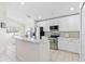 Bright kitchen features white cabinets, stainless steel appliances, and a breakfast bar with seating at 2641 Big Pine Dr, Holiday, FL 34691