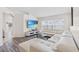 Bright living room with a large white sectional, TV, and a view of the outside through blinds at 2641 Big Pine Dr, Holiday, FL 34691