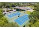 Aerial view featuring community tennis courts, and surrounding green landscaping at 2641 Big Pine Dr, Holiday, FL 34691