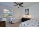 Bright bedroom features two twin beds, ceiling fan, neutral paint and carpet at 2870 Rampart Cir, Clearwater, FL 33761