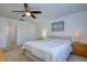 Bright bedroom features ensuite bath, ceiling fan, neutral paint and carpet at 2870 Rampart Cir, Clearwater, FL 33761