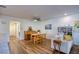 Open-concept dining and living area with wood floors, natural light, a piano, and a modern ceiling fan at 2870 Rampart Cir, Clearwater, FL 33761