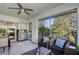 Outdoor lanai featuring tiled floor, ceiling fan, pond view, stainless grill and comfortable seating at 2870 Rampart Cir, Clearwater, FL 33761