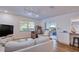 Bright living room with wood flooring, a modern sofa, natural light, and sliding door access to outdoor space at 2870 Rampart Cir, Clearwater, FL 33761