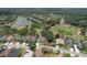 Overhead view of a residential neighborhood, showcasing houses, streets, golf course, and pond, surrounded by trees at 3350 Stonebridge Trl, Valrico, FL 33596