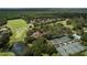 An aerial view highlights a golf course with water features, tennis courts, and clubhouse nestled among trees and residential homes at 3350 Stonebridge Trl, Valrico, FL 33596