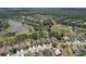 An overhead view of a residential area showcasing houses, streets, a golf course, and a scenic pond amidst lush greenery at 3350 Stonebridge Trl, Valrico, FL 33596