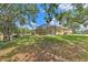 Large lush green backyard with a screened patio and mature trees, offering an ideal space for relaxation and outdoor activities at 3350 Stonebridge Trl, Valrico, FL 33596