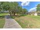 Expansive backyard with a walkway, lush green grass, mature trees and view of home at 3350 Stonebridge Trl, Valrico, FL 33596