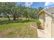 Spacious backyard with manicured lawn, beautiful landscaping, and lush trees at 3350 Stonebridge Trl, Valrico, FL 33596
