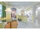 Bright dining area with tile flooring, tropical wallpaper, and direct access to the kitchen and front entry at 3350 Stonebridge Trl, Valrico, FL 33596