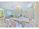 Spacious dining room with a crystal chandelier, draped windows, and a formal dining setup with living room views at 3350 Stonebridge Trl, Valrico, FL 33596