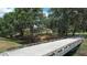 Scenic exterior view with a bridge over a stream leading to a charming home surrounded by mature trees at 3350 Stonebridge Trl, Valrico, FL 33596