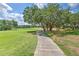 Walking path to the lush golf course, surrounded by mature trees and green grass at 3350 Stonebridge Trl, Valrico, FL 33596