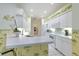 Well-lit kitchen featuring white cabinetry, appliances, and a breakfast bar with palm tree wallpaper at 3350 Stonebridge Trl, Valrico, FL 33596