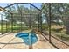 Relaxing screened-in pool area with a rock waterfall feature, backing onto green space at 3350 Stonebridge Trl, Valrico, FL 33596