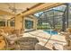 Relaxing screened-in pool area with a rock waterfall feature, view from outdoor seating area at 3350 Stonebridge Trl, Valrico, FL 33596
