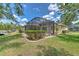 Enclosed screened patio with a well-maintained lawn, lovely landscaping, and view of the home's back exterior at 3350 Stonebridge Trl, Valrico, FL 33596