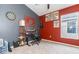 A gray and red bedroom that is set up as an office space with a dartboard and guitar at 34447 Blue Ash Ct, Wesley Chapel, FL 33545