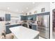Well-lit kitchen featuring stainless steel appliances, modern blue cabinets, and a breakfast bar at 34447 Blue Ash Ct, Wesley Chapel, FL 33545