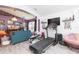 Cozy living room featuring a treadmill, adjacent to a comfortable sitting area with unique decor at 34447 Blue Ash Ct, Wesley Chapel, FL 33545