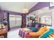 Inviting living room with stylish furniture, a bar, and a view into a sunny, plant-filled adjacent room at 34447 Blue Ash Ct, Wesley Chapel, FL 33545