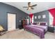 Main bedroom features gray walls, ceiling fan and adjacent bathroom and walk-in closet at 34447 Blue Ash Ct, Wesley Chapel, FL 33545