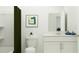 A minimalist bathroom features a white vanity and a shower with a green curtain at 3465 Lapis Lake Dr, Zephyrhills, FL 33541