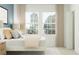 A sun-filled bedroom boasts neutral décor with cozy textiles and tranquil outdoor views at 3481 Lapis Lake Dr, Zephyrhills, FL 33541