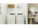 Bright laundry area featuring a modern washer and dryer with upper shelf storage, maximizing space at 3481 Lapis Lake Dr, Zephyrhills, FL 33541