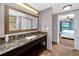 Bathroom featuring granite counters, large mirror, and access to bedroom at 399 2Nd St # 217, Indian Rocks Beach, FL 33785