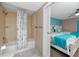 Bathroom and bedroom featuring a bathtub with shower and a room with two cozy beds at 399 2Nd St # 217, Indian Rocks Beach, FL 33785