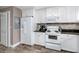 Well-lit kitchen with white cabinetry, stylish backsplash, and modern appliances, creating a clean and inviting space at 399 2Nd St # 217, Indian Rocks Beach, FL 33785