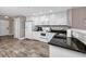 Well-lit kitchen with white cabinets, granite counters, and wood-look tile floor at 399 2Nd St # 217, Indian Rocks Beach, FL 33785
