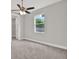 Bedroom featuring neutral walls, cozy carpet, ceiling fan, and a large window at 4071 45Th N Ave, St Petersburg, FL 33714