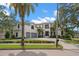 Stunning two-story home showcasing lush landscaping, palm trees, and a convenient two-car garage at 419 S Shore Crest Dr, Tampa, FL 33609