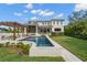 Luxury home exterior with a pool, pergola, and lush green lawn at 419 S Shore Crest Dr, Tampa, FL 33609