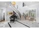 Elegant foyer featuring a curved staircase with iron railings, grand piano, and decorative lighting at 419 S Shore Crest Dr, Tampa, FL 33609