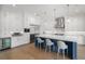 Bright kitchen featuring white cabinets, stainless appliances, hardwood floors and blue island with quartz countertops at 419 S Shore Crest Dr, Tampa, FL 33609