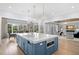 Bright kitchen featuring white cabinets, stainless appliances, hardwood floors and blue island with quartz countertops at 419 S Shore Crest Dr, Tampa, FL 33609