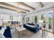 Open-concept living area with beamed ceilings, kitchen view, French doors, and elegant furnishings at 419 S Shore Crest Dr, Tampa, FL 33609