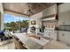 Well-equipped outdoor kitchen featuring stainless steel appliances, custom backsplash, and ample dining space at 419 S Shore Crest Dr, Tampa, FL 33609