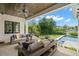 Covered patio with wicker furniture offers a view of the pool and lush backyard at 419 S Shore Crest Dr, Tampa, FL 33609
