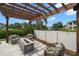 Outdoor seating area under a wood pergola, with a stone fire pit and well landscaped yard at 419 S Shore Crest Dr, Tampa, FL 33609