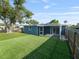 Well kept backyard with artificial grass, privacy fence, shade tree, and covered patio at 4238 Glissade Dr, New Port Richey, FL 34652
