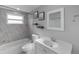 Clean bathroom with updated fixtures, marble tile shower and flooring, and recessed lighting at 4238 Glissade Dr, New Port Richey, FL 34652