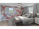 Staged bedroom with wood floor, ceiling fan, large windows, and a geometrically painted wall at 4238 Glissade Dr, New Port Richey, FL 34652