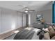 Staged bedroom with gray walls, wood floor, ceiling fan, neutral toned decor, and two closets at 4238 Glissade Dr, New Port Richey, FL 34652